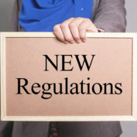 A pink sign that reads "new regulations" as laws look to improve the current system