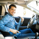 Man sitting in car seat fastening seat belt