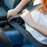 Woman fastens a seat belt. Safe driving concept